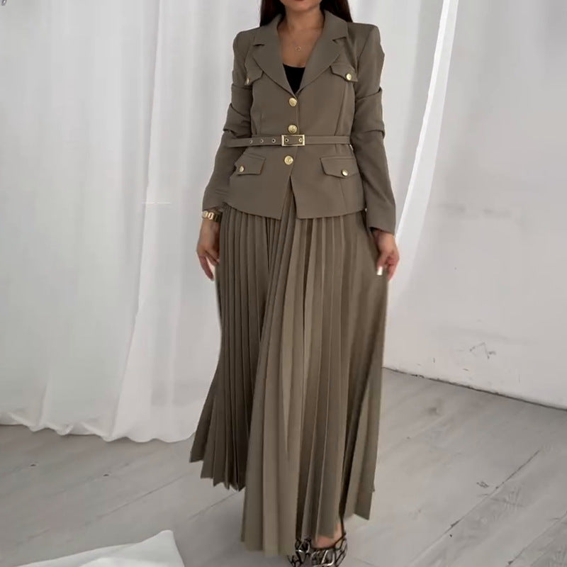 Donna in abito elegante marrone con giacca a doppio petto e gonna plissettata, sfondo bianco. Moda femminile, abbigliamento formale, stile sofisticato.