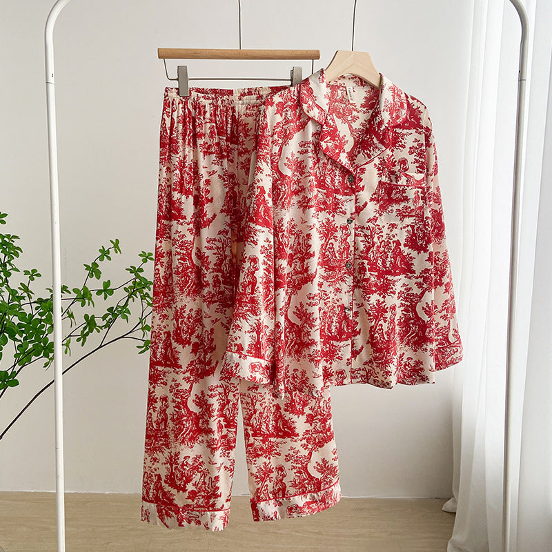 Pigiama donna in raso rosso e bianco con stampa floreale, appeso su appendiabiti in una stanza luminosa. Elegante e confortevole.
