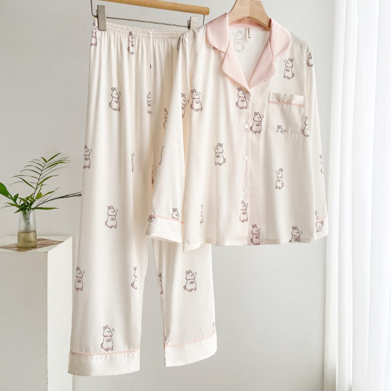Pigiama donna in seta bianca con stampa orsetti, appeso su gruccia. Design elegante e confortevole, ideale per la notte. Arredamento minimalista.