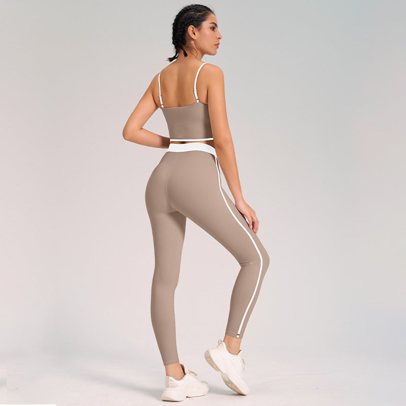 Donna in abbigliamento sportivo beige, top e leggings aderenti, posa di profilo. Moda fitness, abbigliamento palestra, stile athleisure.