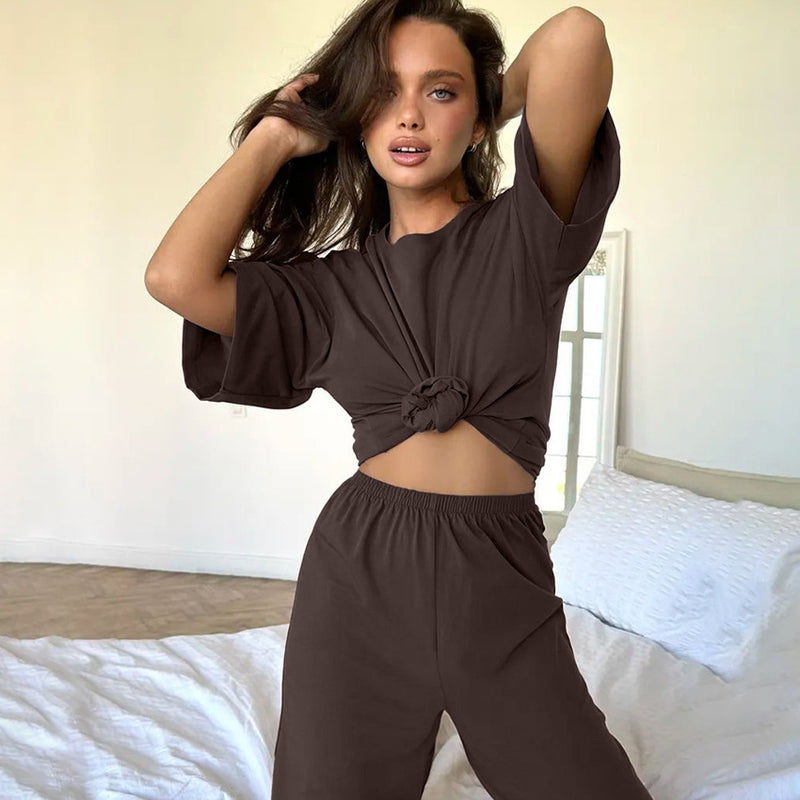 Donna in abbigliamento loungewear marrone, posa in camera da letto moderna. Moda casual, comfort, stile rilassato.