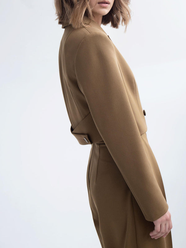 Donna in abito marrone elegante, taglio sartoriale, sfondo bianco. Moda femminile, stile minimalista, abbigliamento autunnale, tendenze 2023.