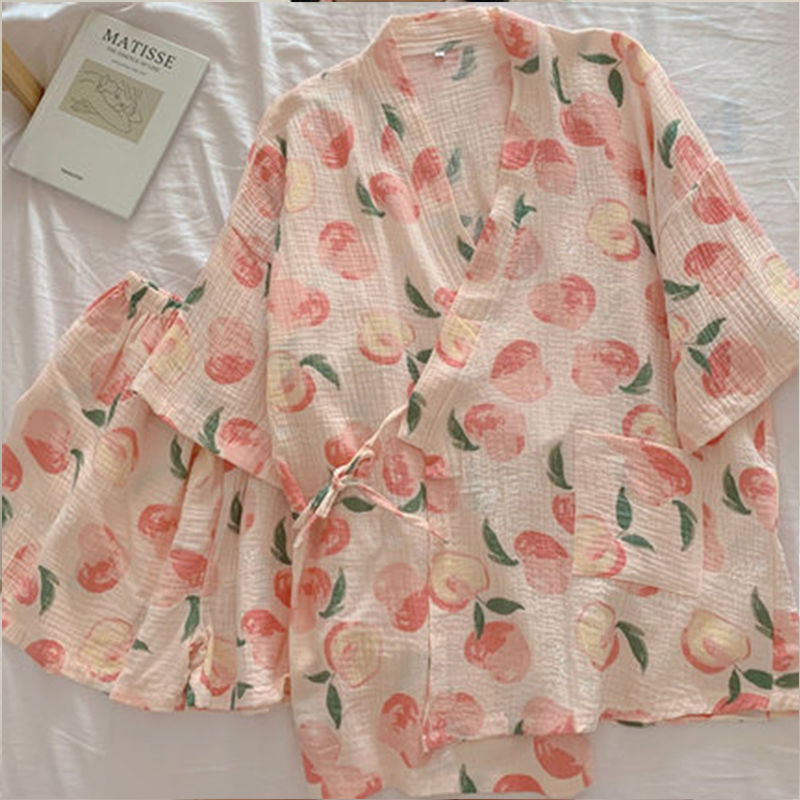 Kimono in cotone con stampa di pesche su sfondo rosa, stile casual estivo. Design leggero e traspirante, perfetto per giornate calde.