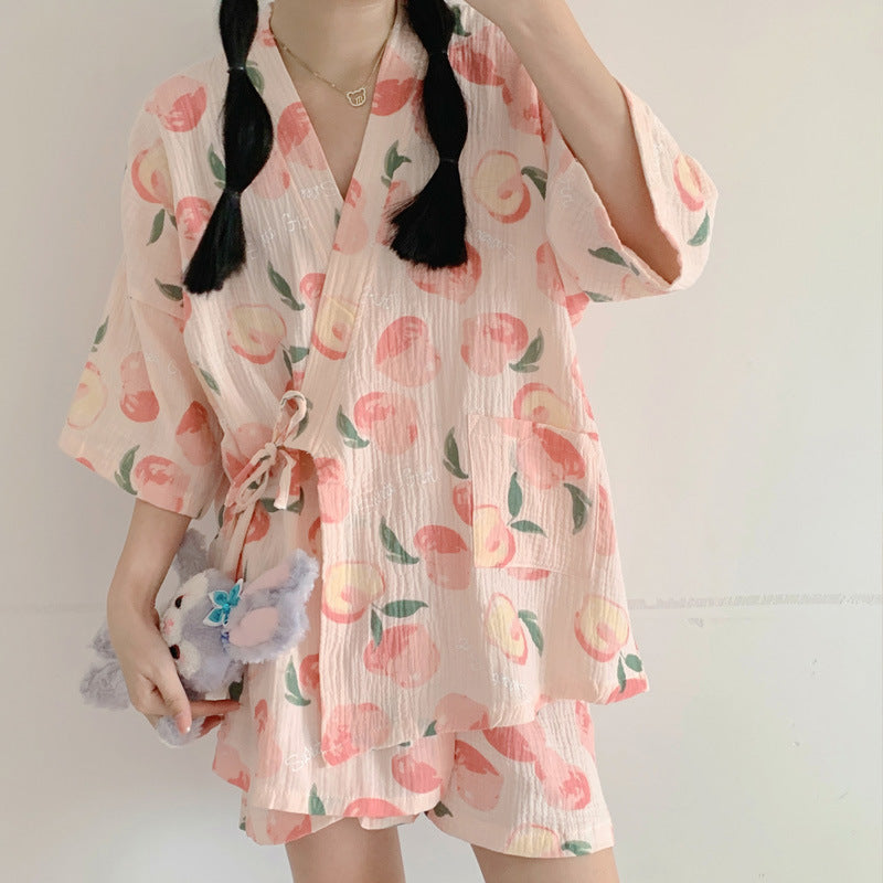 Kimono estivo donna con stampa pesche, maniche ampie, tessuto leggero, abbinato a shorts coordinati. Look casual e fresco per l'estate.