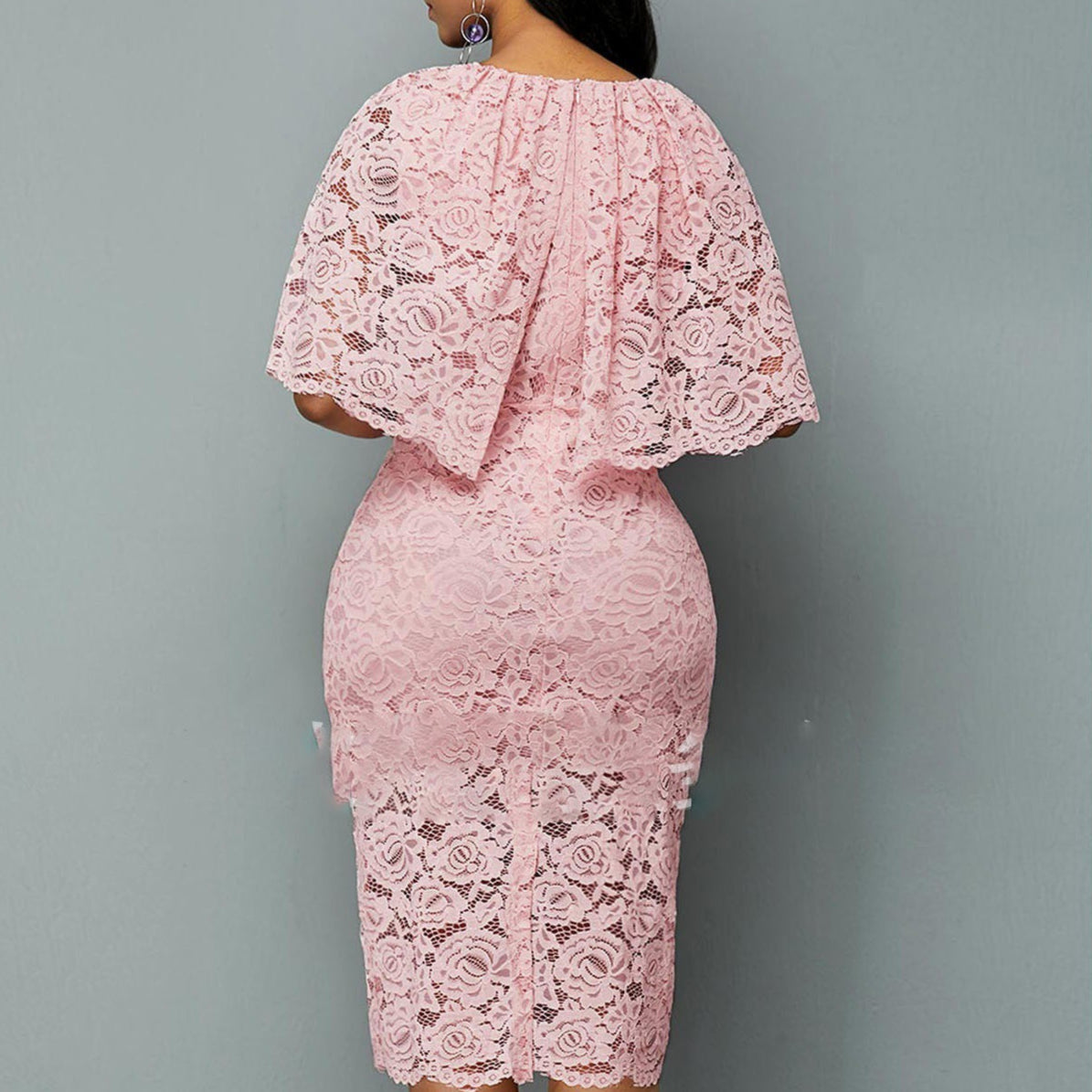 Abito in pizzo rosa, elegante e femminile, con maniche a mantella e lunghezza al ginocchio. Perfetto per cerimonie e occasioni speciali.