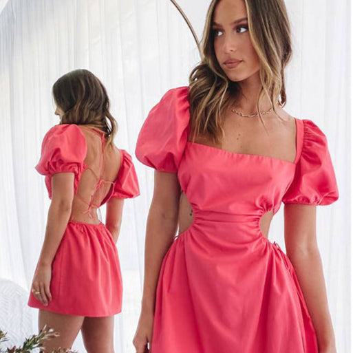 Donna in abito rosa con maniche a sbuffo e schiena scoperta, riflessa in uno specchio. Moda elegante, abbigliamento femminile, tendenze 2023.