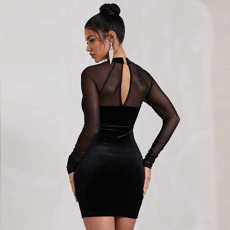 Abito nero elegante con maniche trasparenti e scollatura posteriore, indossato da una donna con capelli raccolti e orecchini pendenti.