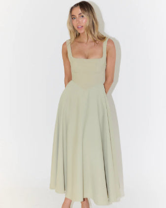 Donna in abito lungo verde chiaro, senza maniche, con scollo quadrato. Moda elegante, abbigliamento estivo, stile casual chic.