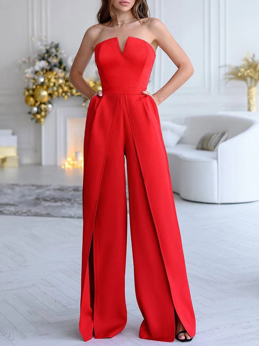 Donna in elegante tuta rossa senza spalline, sfondo natalizio con decorazioni dorate e albero di Natale, soggiorno moderno.