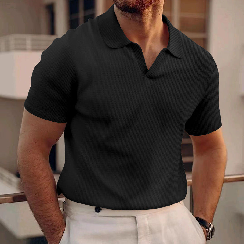 Uomo con polo nera elegante e pantaloni bianchi, appoggiato a una ringhiera. Moda maschile, abbigliamento casual chic, stile estivo urbano.
