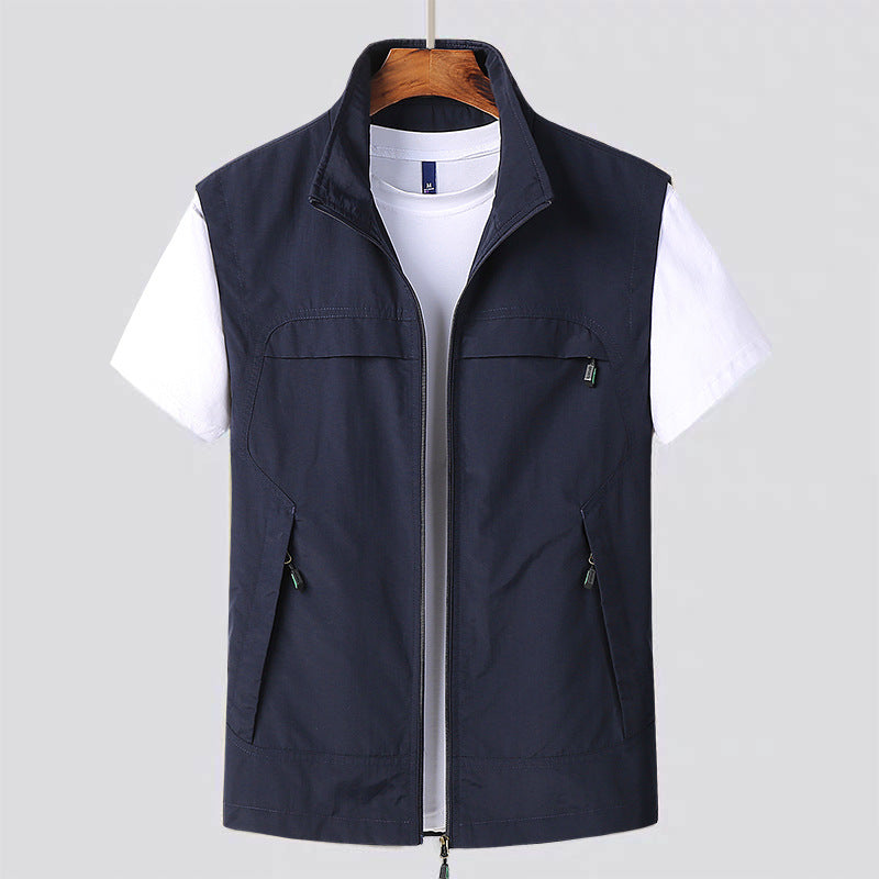 Gilet blu scuro da uomo su gruccia, con zip e tasche, sopra t-shirt bianca. Moda casual, abbigliamento maschile, stile versatile.