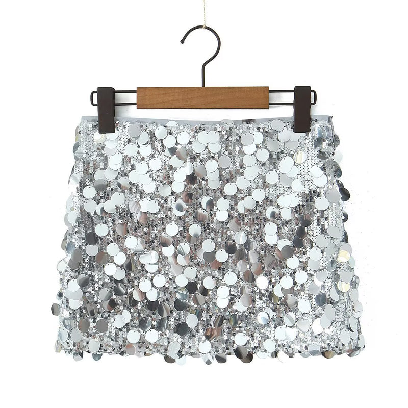 Gonna corta in paillettes argentate, appesa su gruccia di legno. Moda femminile, abbigliamento elegante, stile glamour, tessuto scintillante.