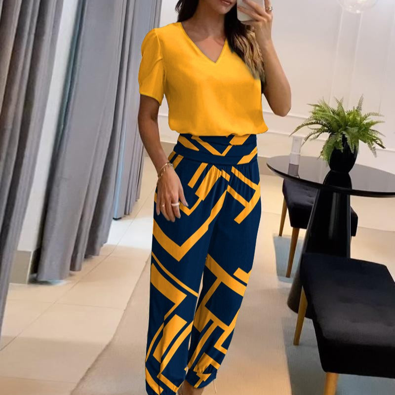 Donna in abbigliamento elegante: maglia gialla e pantaloni blu con motivi geometrici gialli. Moda femminile, stile moderno, outfit casual chic.