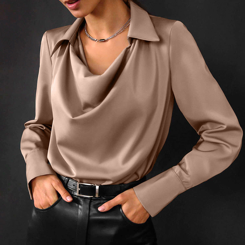 Camicia elegante in raso color beige con colletto e maniche lunghe, indossata con pantaloni neri in pelle. Look sofisticato e moderno.
