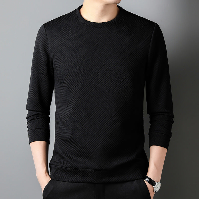 Maglia nera a maniche lunghe con motivo geometrico, indossata da una persona su sfondo grigio. Moda uomo, abbigliamento casual elegante.