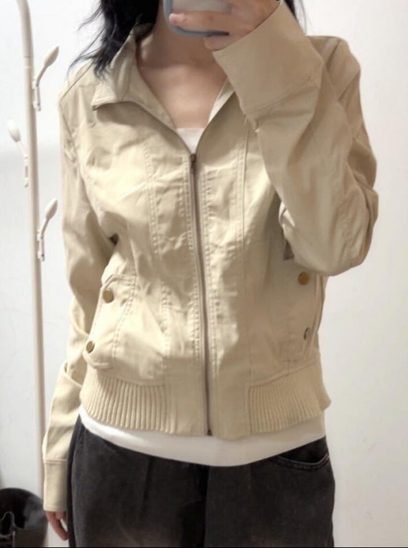 Giacca beige da donna con cerniera, indossata sopra una maglietta bianca. Stile casual, perfetta per la moda autunnale.