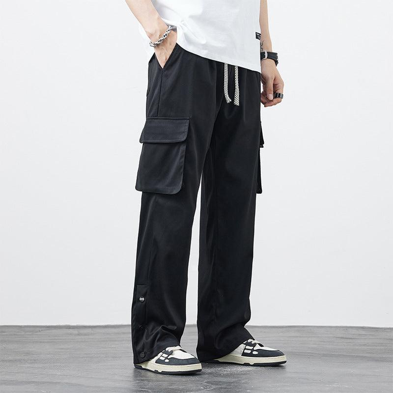 Pantaloni cargo neri da uomo con tasche laterali, indossati con sneakers bianche e nere. Stile casual, moda urbana, abbigliamento maschile moderno.