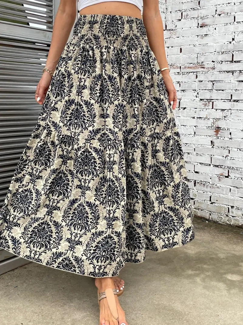 Gonna lunga a vita alta con motivo floreale nero su sfondo beige, indossata da una donna. Perfetta per moda estiva e look casual eleganti.