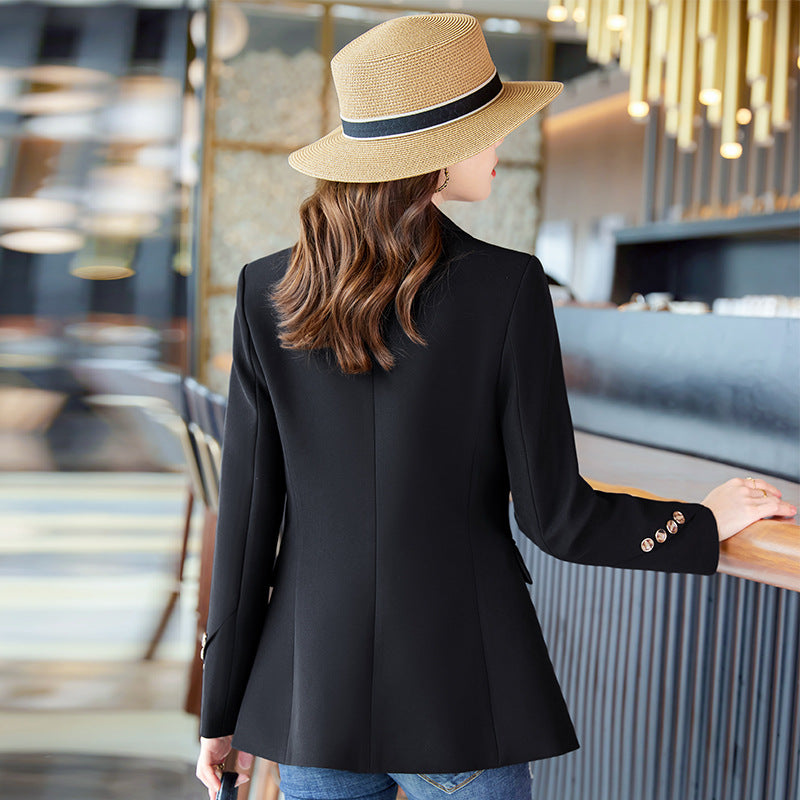 Donna elegante con cappello di paglia e giacca nera in un moderno bar. Moda femminile, stile urbano, abbigliamento casual chic.