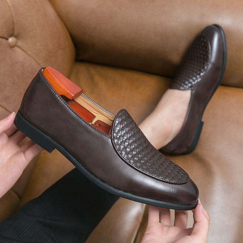 Scarpe mocassini in pelle marrone scuro con motivo intrecciato, su divano in pelle. Eleganti e moderne, ideali per moda maschile e abbigliamento formale.