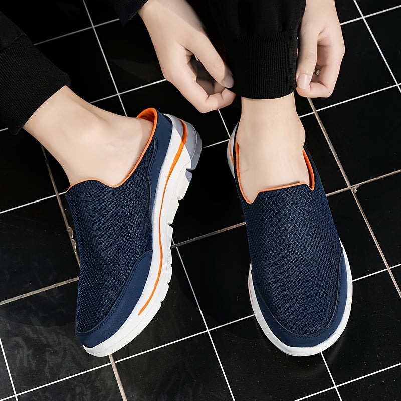 Scarpe slip-on blu scuro con suola bianca e dettagli arancioni, indossate su piastrelle nere. Calzature casual estive, comode e traspiranti.