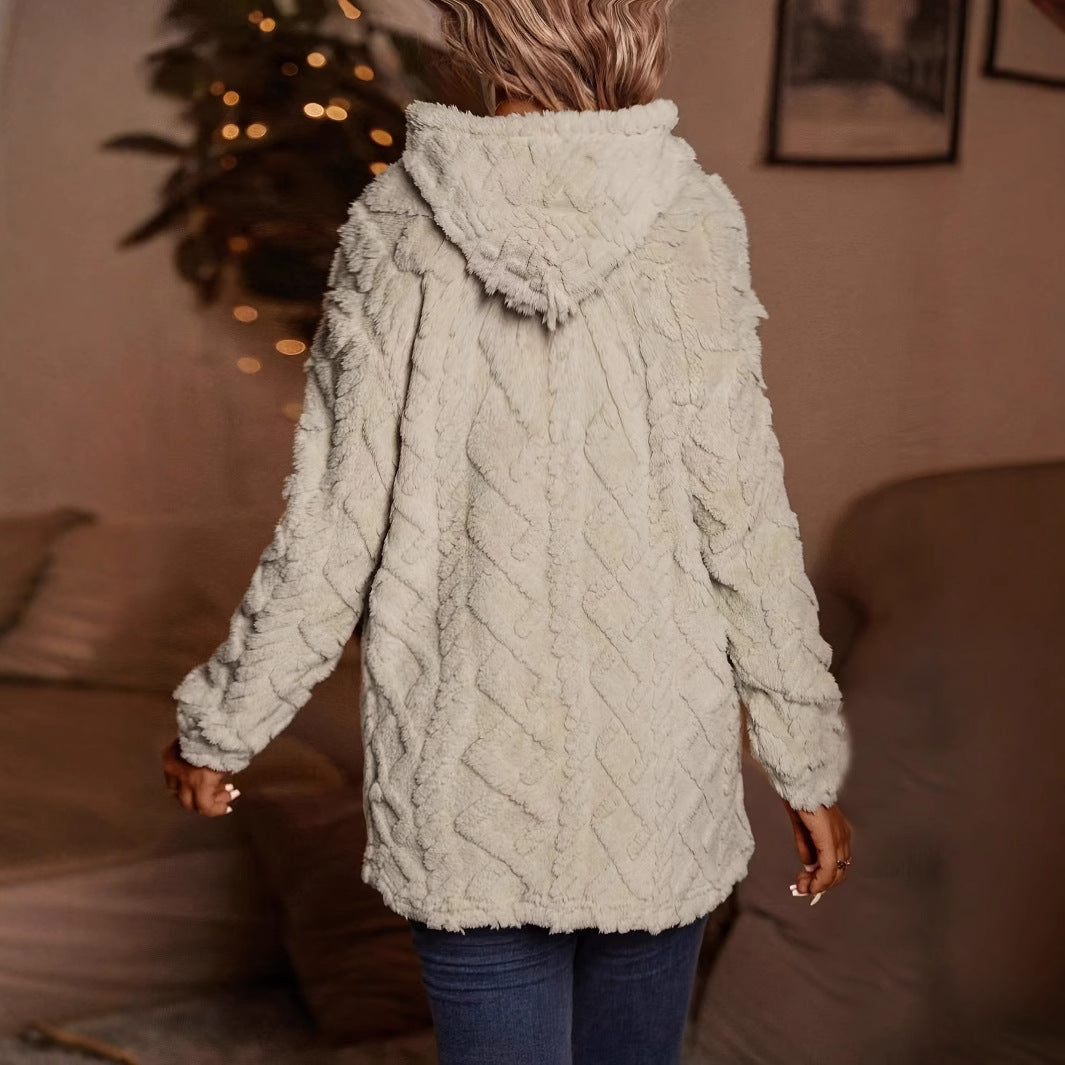 Donna di spalle con cappotto in pelliccia sintetica bianca, cappuccio, in un ambiente accogliente. Moda invernale, abbigliamento caldo e confortevole.