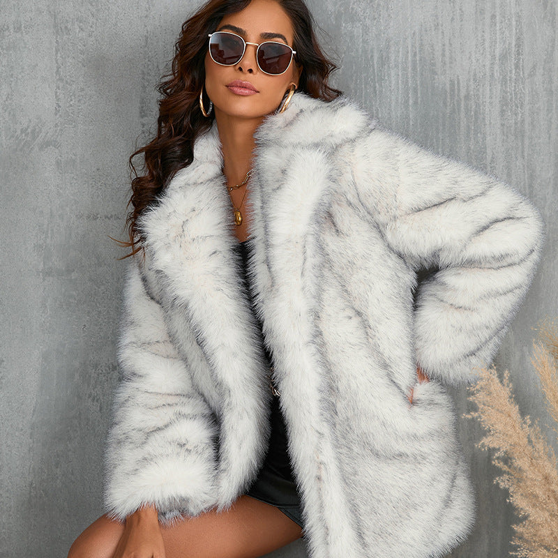 Donna con cappotto di pelliccia bianca, occhiali da sole e abito nero, posa elegante contro sfondo grigio. Moda invernale, stile glamour.