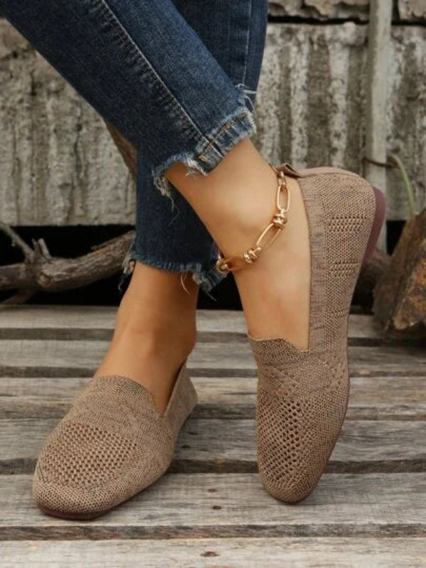 Scarpe mocassini beige in maglia, indossate con jeans strappati. Calzature casual eleganti, ideali per moda donna e comfort quotidiano.