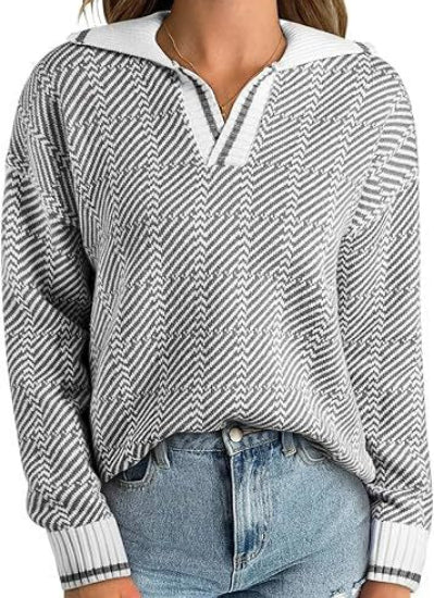 Maglione donna a righe bianche e grigie, collo a V, abbinato a jeans blu chiaro. Moda casual autunnale, stile confortevole e trendy.