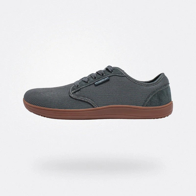 Scarpa casual uomo grigia, suola marrone, tessuto traspirante, design moderno, perfetta per passeggiate e uso quotidiano. Scarpe comode e versatili.