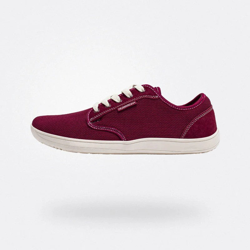 Scarpa da ginnastica rossa in tessuto, suola bianca, design casual, lacci bianchi, vista laterale. Scarpe sportive uomo, moda urbana.
