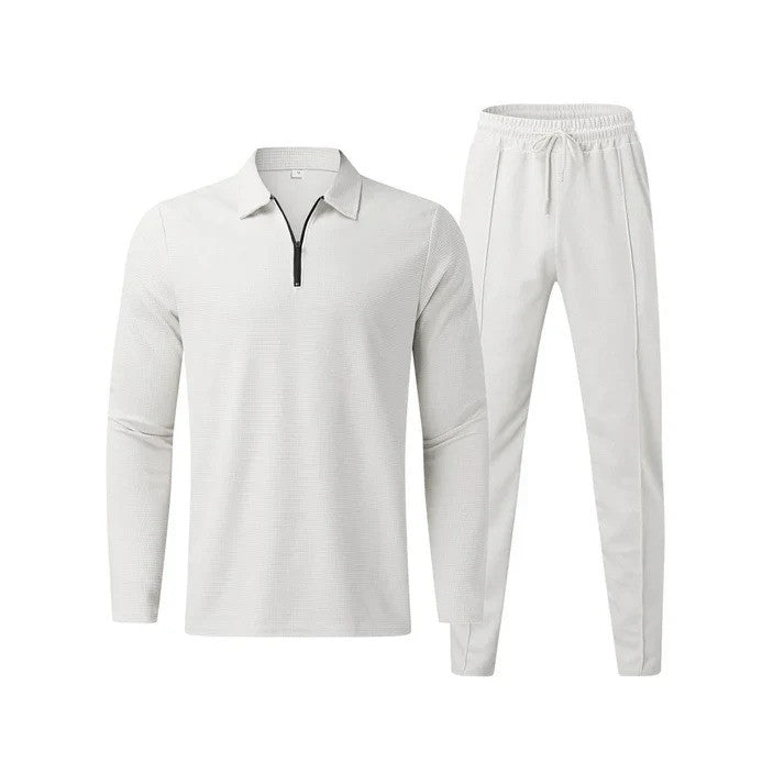 Completo sportivo bianco da uomo, composto da maglia a maniche lunghe con zip e pantaloni con coulisse. Abbigliamento casual elegante e confortevole.