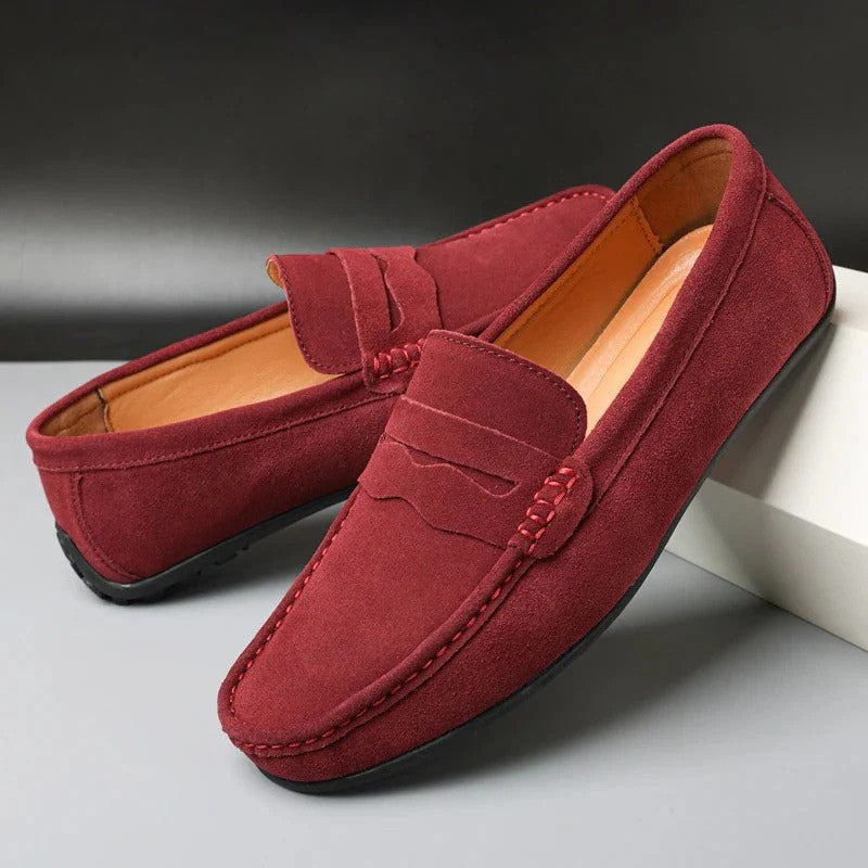 Mocassini uomo in pelle scamosciata rossa, suola in gomma nera, design elegante e casual, perfetti per moda autunnale e look quotidiano.
