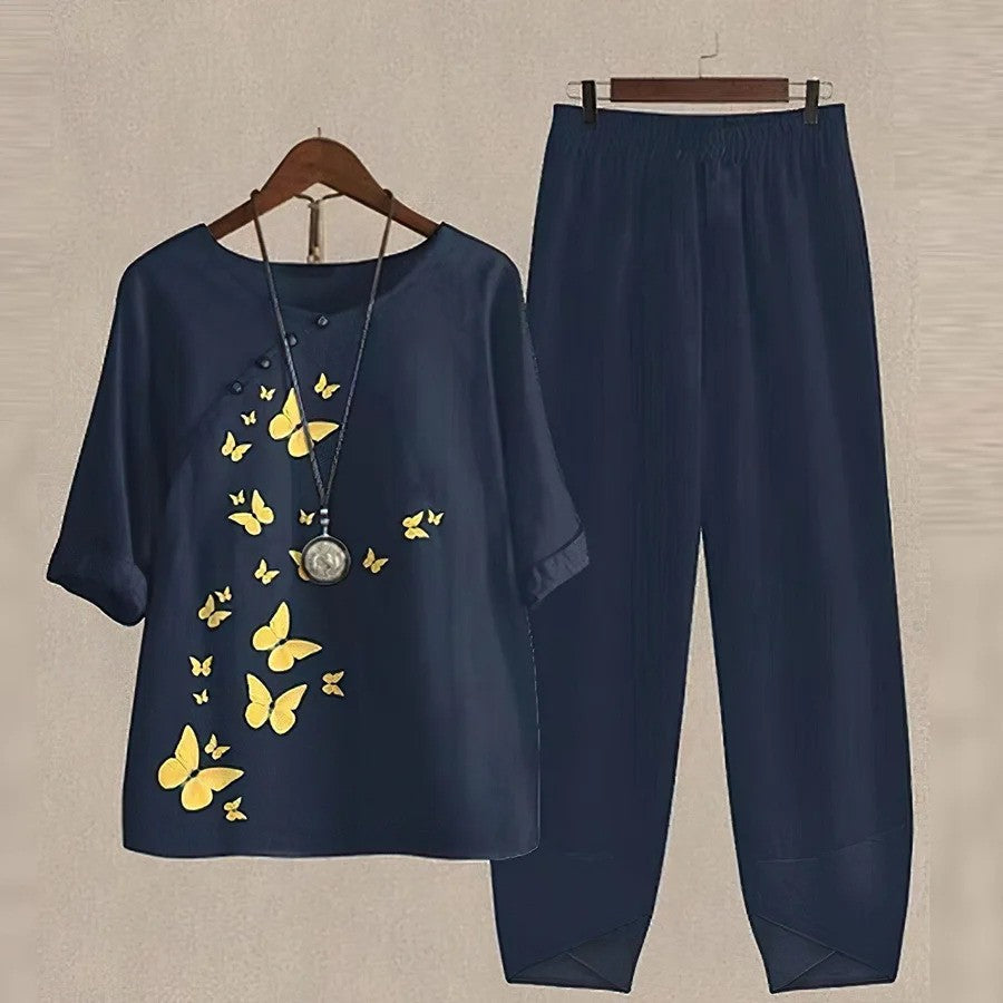 Completo donna blu scuro con maglia a farfalle gialle e pantaloni abbinati, moda casual elegante, abbigliamento estivo, stile confortevole.