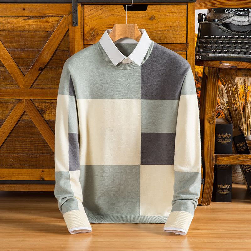 Maglione a quadri grigio e bianco con colletto camicia, appeso su gruccia di legno, sfondo rustico con macchina da scrivere vintage e fiori secchi.