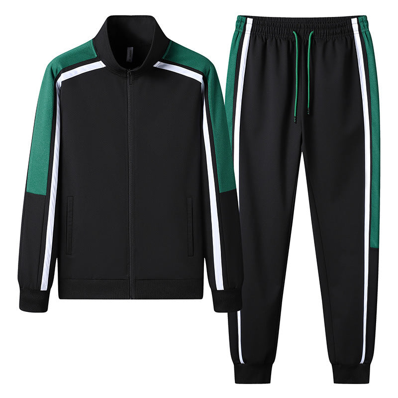 Tuta sportiva nera con dettagli verdi e bianchi, composta da giacca con zip e pantaloni con elastico. Abbigliamento atletico moderno e casual.