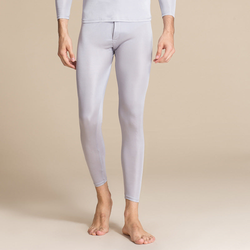 Uomo in leggings termici grigi, a figura intera, su sfondo neutro. Abbigliamento sportivo, comfort, moda maschile, intimo termico.