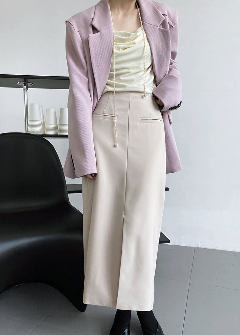 Donna in abito elegante: giacca rosa, top avorio, gonna beige. Moda femminile, abbigliamento formale, stile sofisticato.