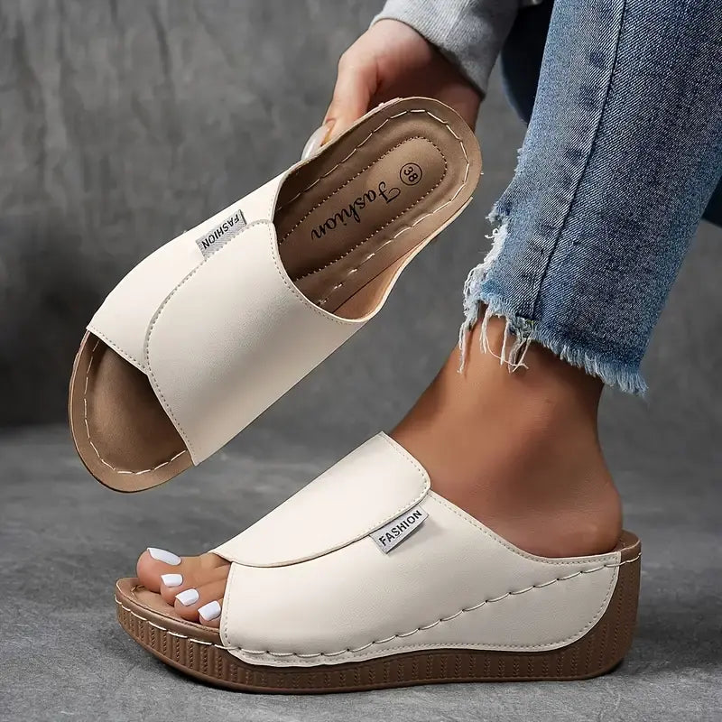 Sandali donna bianchi con zeppa, indossati con jeans strappati. Design moderno, comodi per l'estate. Scarpe casual eleganti.