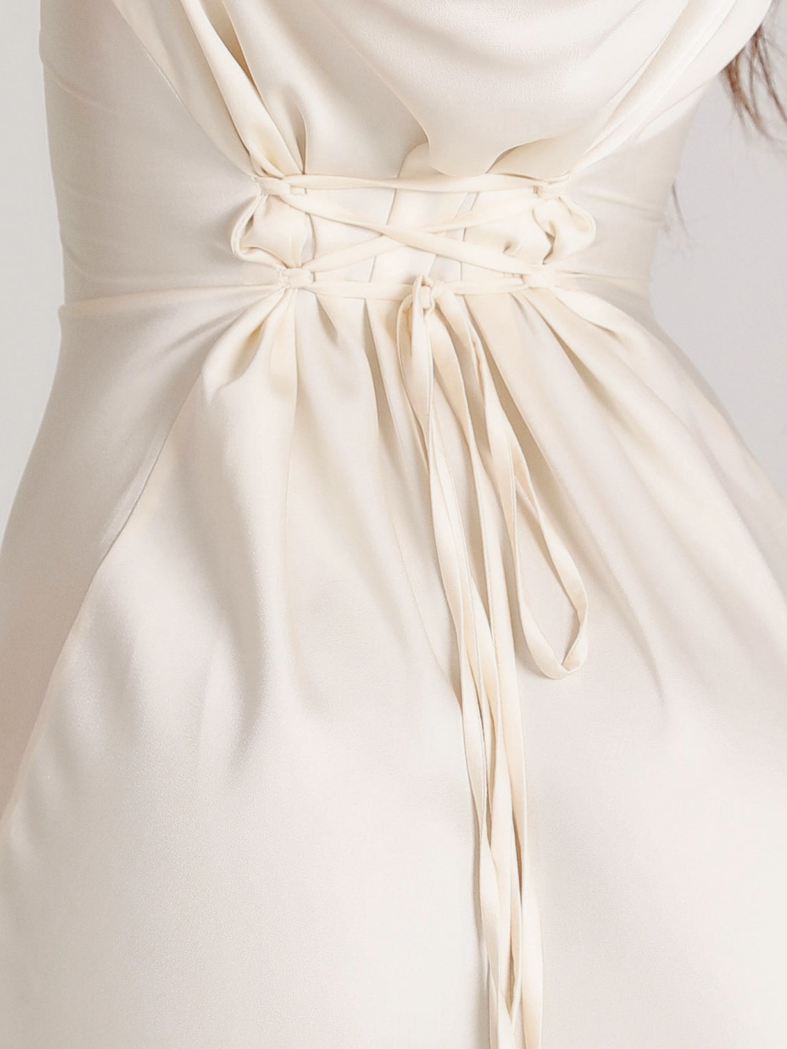 Abito da sposa avorio con corsetto intrecciato, tessuto satinato, dettagli eleganti e raffinati, moda nuziale, design sofisticato.