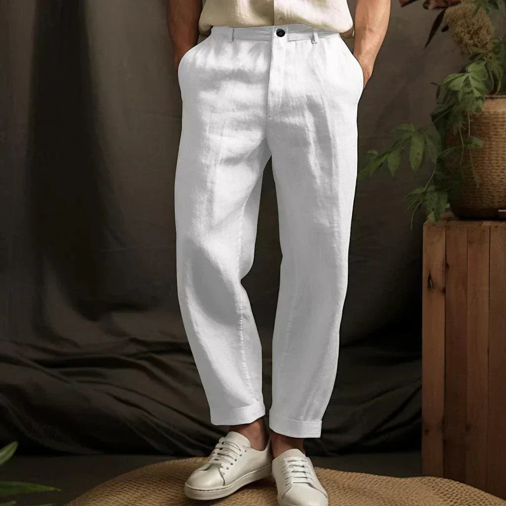 Pantaloni bianchi in lino da uomo, eleganti e casual, abbinati a scarpe bianche. Perfetti per look estivi e rilassati.
