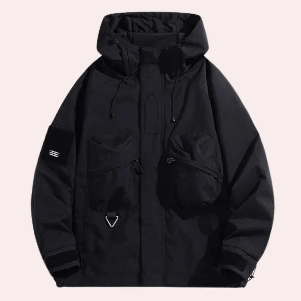 Giacca nera impermeabile con cappuccio, tasche multiple e chiusura a zip. Design moderno e funzionale, ideale per attività all'aperto.