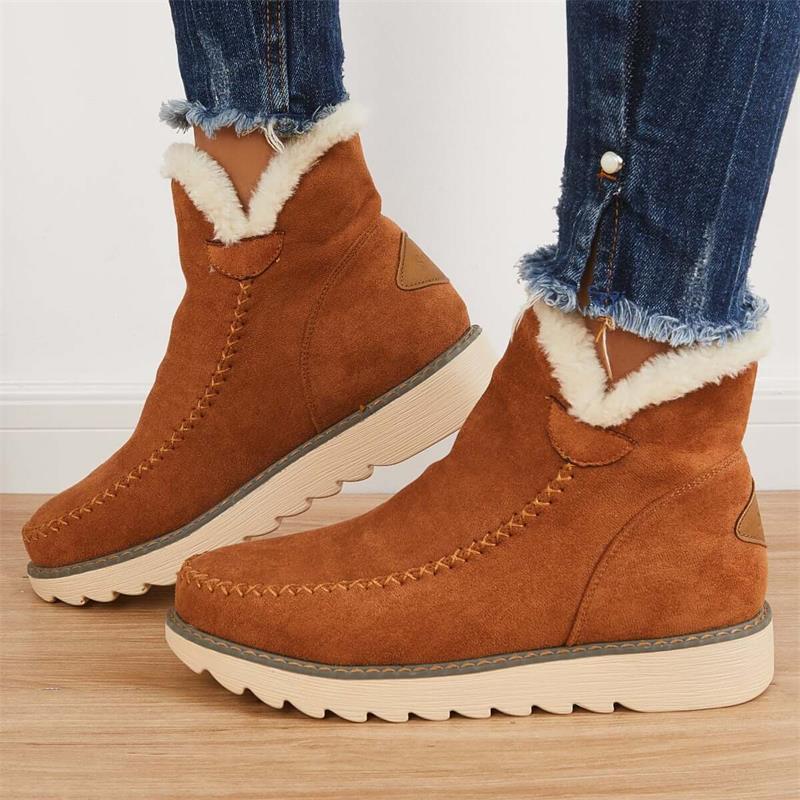 Stivaletti invernali marroni in pelle scamosciata con fodera in pelliccia sintetica, suola antiscivolo, indossati con jeans.