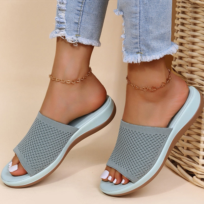 Sandali estivi donna in maglia grigia, suola comoda, abbinati a jeans strappati. Moda casual, calzature trendy, stile estivo.