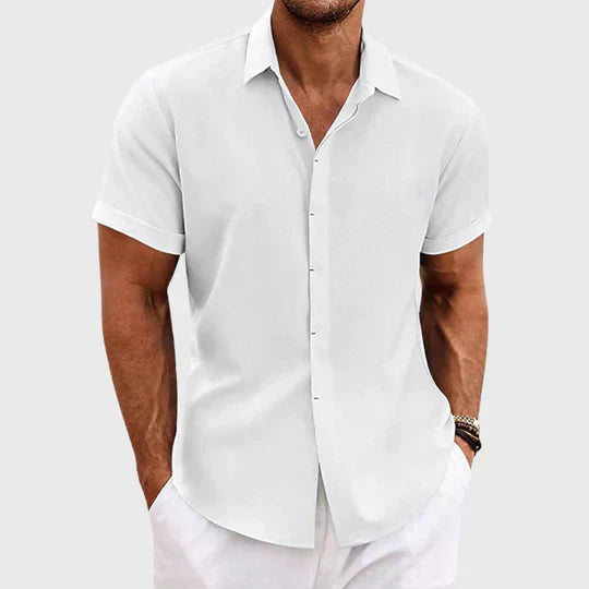 Camicia bianca da uomo a maniche corte, stile casual elegante, indossata con pantaloni bianchi. Ideale per look estivi e occasioni informali.