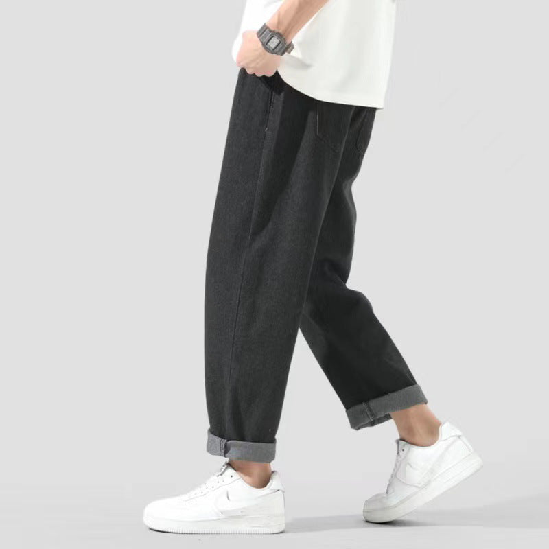 Pantaloni larghi neri da uomo, stile casual, abbinati a scarpe da ginnastica bianche e maglietta bianca. Moda maschile, abbigliamento urbano.