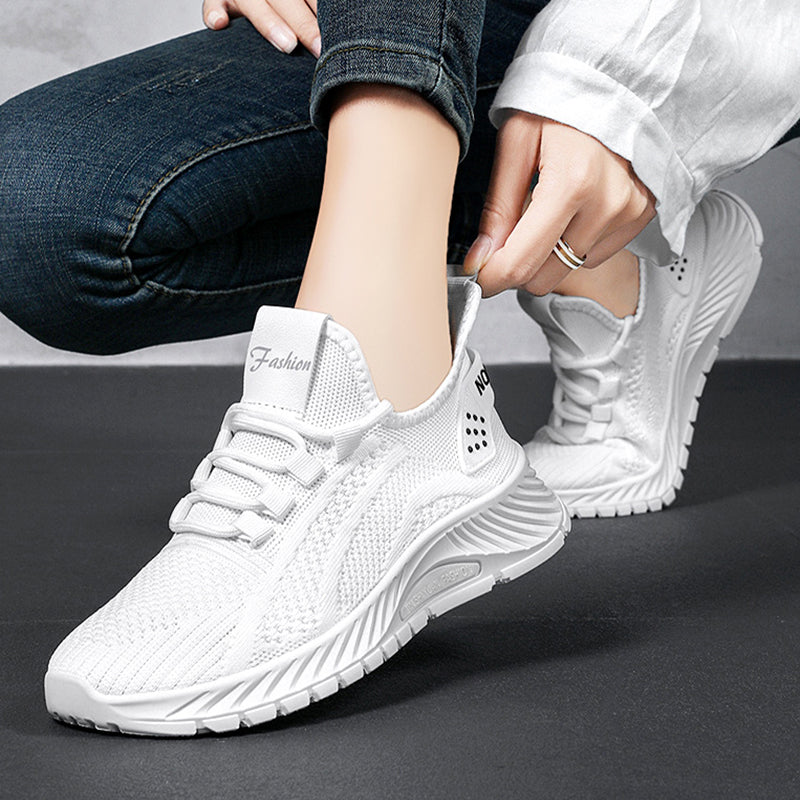 Scarpe da ginnastica bianche moderne, design traspirante, suola ammortizzante, indossate da una persona con jeans. Scarpe sportive eleganti e comode.