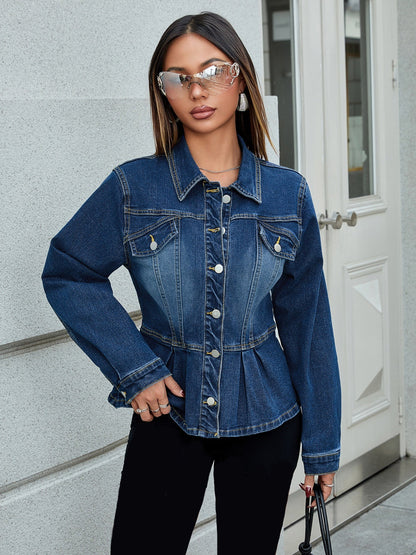 Donna con giacca di jeans blu, occhiali da sole specchiati e pantaloni neri, posa davanti a un edificio moderno. Moda urbana, stile casual chic.