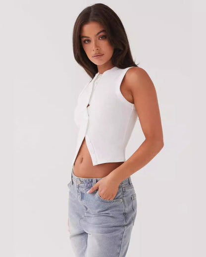 Donna con top bianco senza maniche e jeans chiari, posa su sfondo bianco. Moda casual, abbigliamento estivo, stile minimalista.