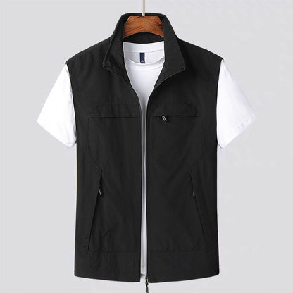 Gilet nero da uomo su gruccia, con zip frontale e tasche, sopra una maglietta bianca. Abbigliamento casual, moda maschile, stile moderno.